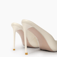 Ivory stiletto mule heel and gold-tone tip detail