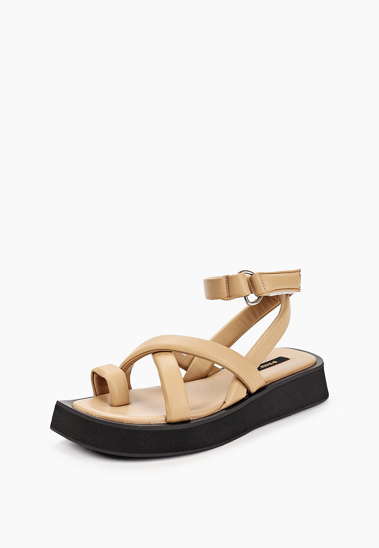 Three-quarter view of beige leather sandals with padded toe loop and black flatform sole