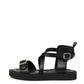 Black leather harness sandals with two silver-tone buckles and low platform, side profile