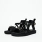 Pair of black leather platform sandals with front and ankle buckles, three-quarter view