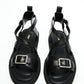 Top view of black genuine leather sandals with crossover straps and antique-silver buckles
