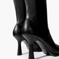 Black knee-high boots with high flared heel and tonal stitching