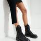 Black leather mesh combat boots worn with a black dress, close styling view
