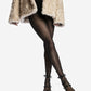 Black leather wraparound heels styled on crossed legs with a textured coat
