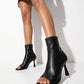 Black stretch-leather open-toe ankle boots worn in studio