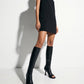 Black stretch microfiber knee-high boots styled with a mini dress