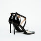 Rear view of black patent ankle-strap heels with slim stiletto heels