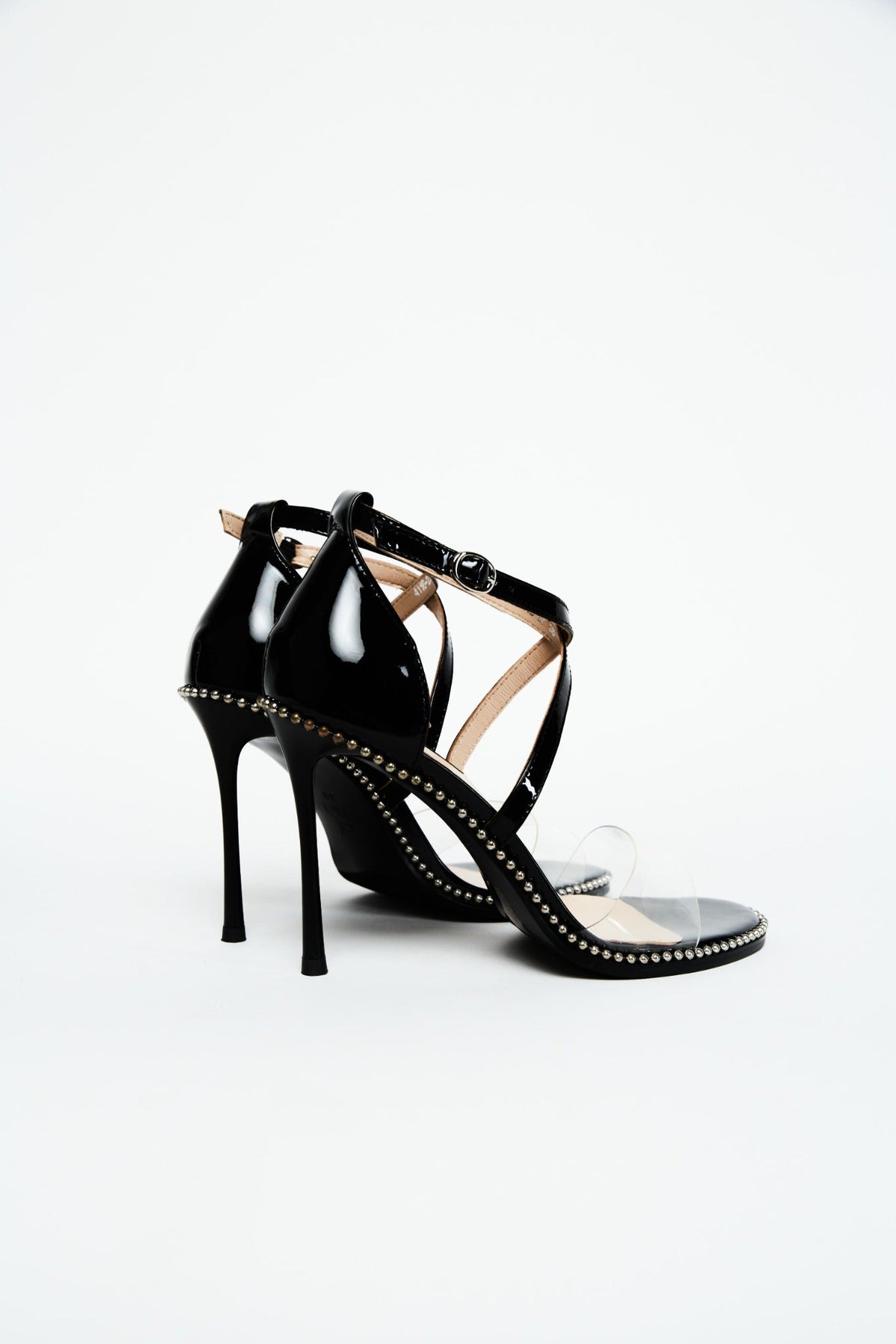 Rear view of black patent ankle-strap heels with slim stiletto heels