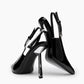 Black patent leather slingback pumps showing the curved profile and clear geometric heel detail