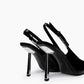Rear view of black patent slingback heels with adjustable straps and transparent stiletto heels