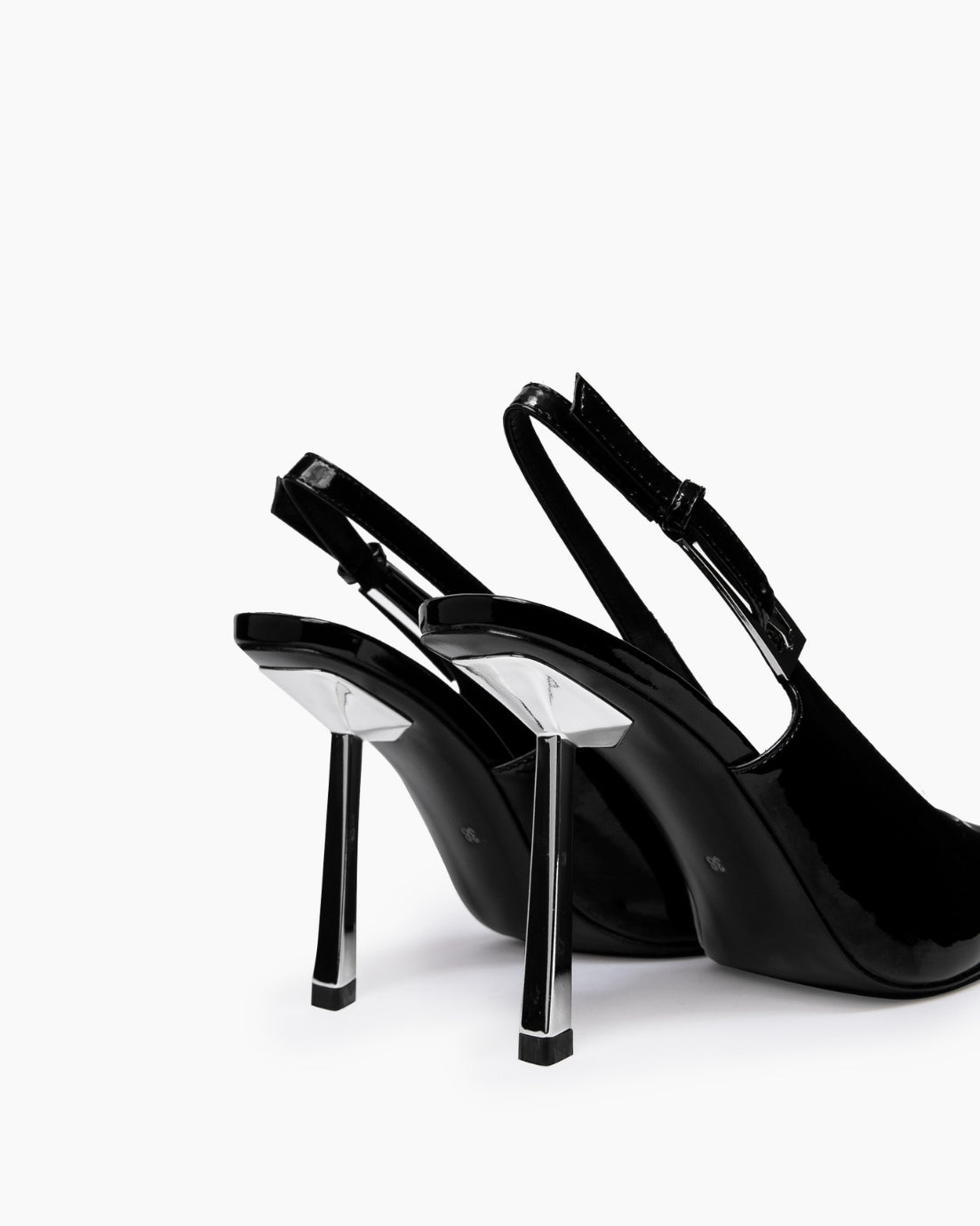 Rear view of black patent slingback heels with adjustable straps and transparent stiletto heels