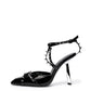 Black patent leather heels with silver-tone spikes and a sculptural silver-tone heel — side view