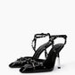Pair of black patent leather spiked heels with ankle straps — three-quarter view