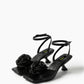 Black leather low-heel sandals with textile rosettes, pair view