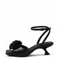 Black leather low-heel sandals with textile rosette, side view