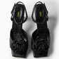 Black leather low-heel sandals with textile rosettes, top view