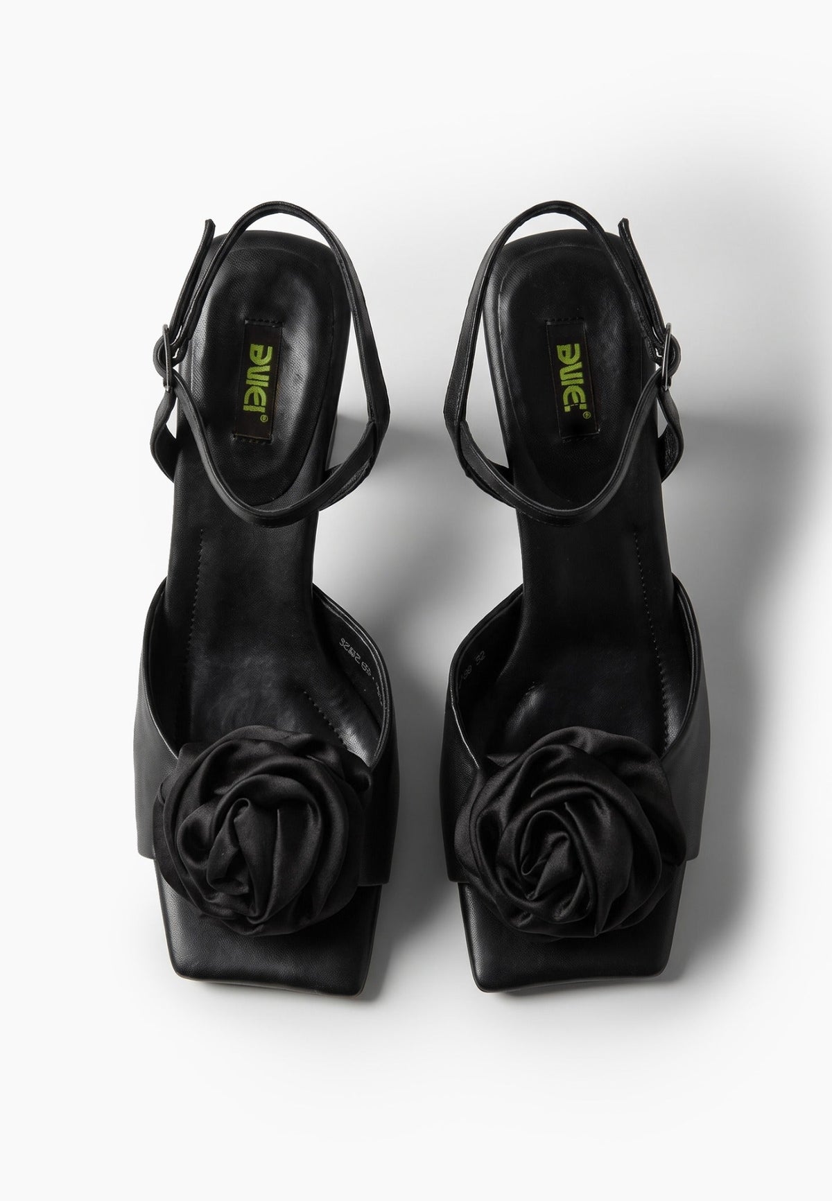 Black leather low-heel sandals with textile rosettes, top view