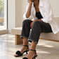 Black rosette sandals styled with charcoal denim in a modern interior