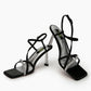 Black satin glitter-strap heels, front three-quarter view