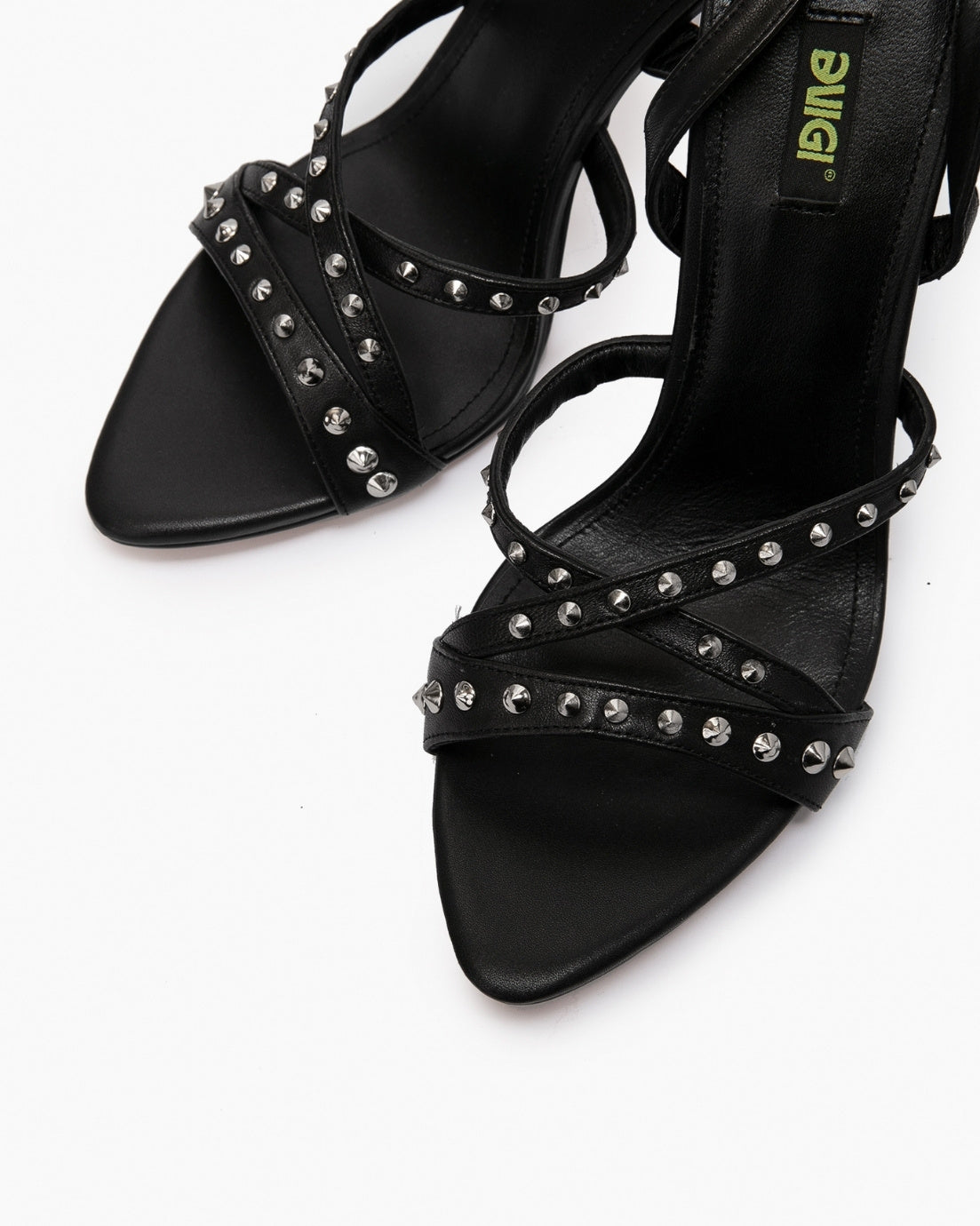 Close-up of black leather cross straps with round silver-tone studs and squared open toes