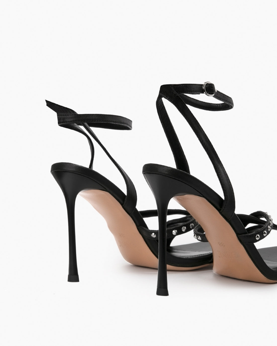 Rear view of black studded leather heels showing slim ankle straps and stiletto heels