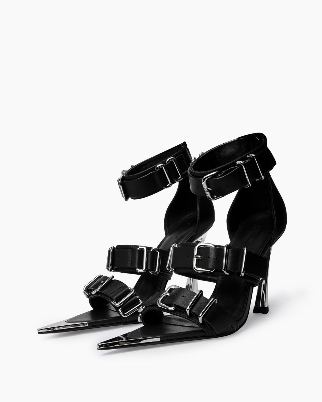 Pair of black leather heels with wide straps, oversized chrome buckles and pointed toe caps
