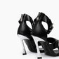 Rear view of black leather heels showing back zips and chrome-coated flared heels