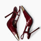 Top view of burgundy patent T-strap heels showing gold metal toes and slim stilettos