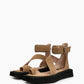 Pair of camel suede buckle sandals with asymmetric straps and black platform soles