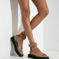 Woman wearing camel suede platform sandals with wide ankle cuffs