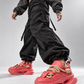 Low-angle streetwear styling of coral sculpted-sole sneakers in motion
