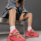 Seated model wearing coral rope-lace sneakers in an industrial studio