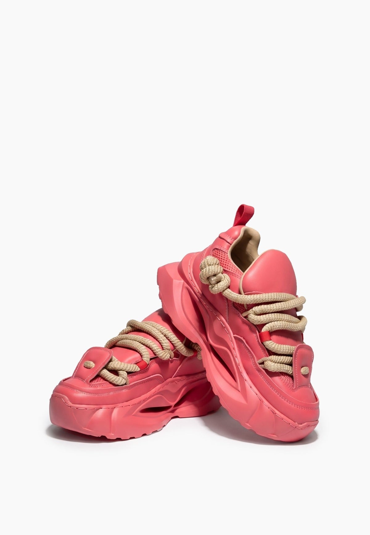 Pair of coral pink chunky sneakers showing rope laces and sculpted soles