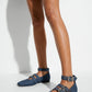 Indigo denim triple-buckle ballet flats worn with a fitted black dress