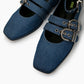 Close-up of blue denim ballet flats showing square toes, eyelets and silver buckles