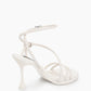 Rear view of ivory ankle-strap heels with trumpet-shaped heel