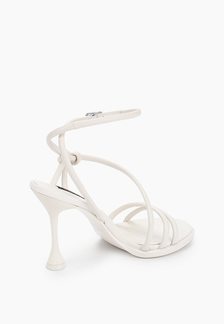 Rear view of ivory ankle-strap heels with trumpet-shaped heel