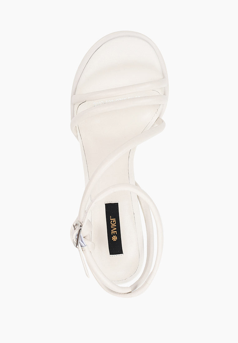 Top view of ivory leather heels with tubular straps and silver buckle