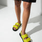 Lime green leather sandals worn in a bright studio, top view