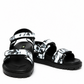 Front angle of black and white brush-print leather sandals with adjustable tabs
