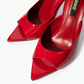 Red patent leather mules with open toe and pointed footbed detail