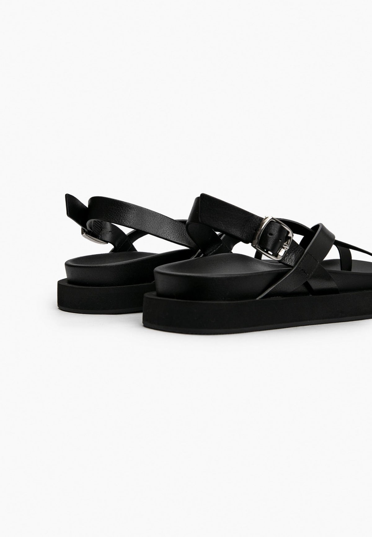 Rear detail of black leather sandal with adjustable silver-tone buckle