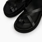 Close-up of smooth black leather straps and cushioned footbed