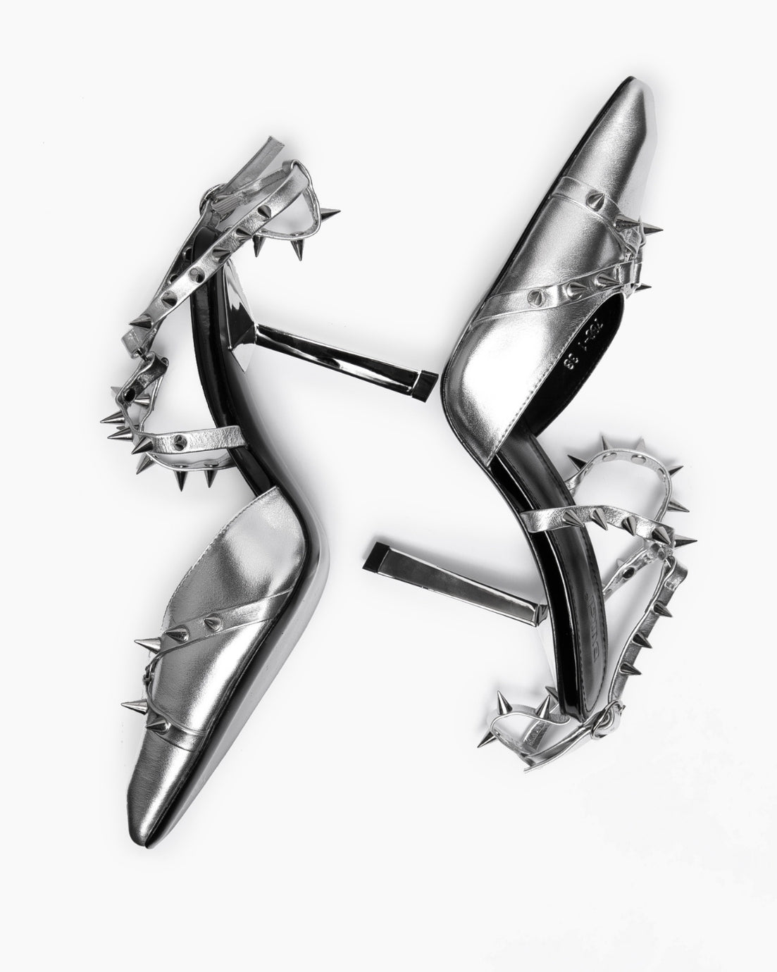 Overhead arrangement of silver leather shoes with contrasting black leather insoles