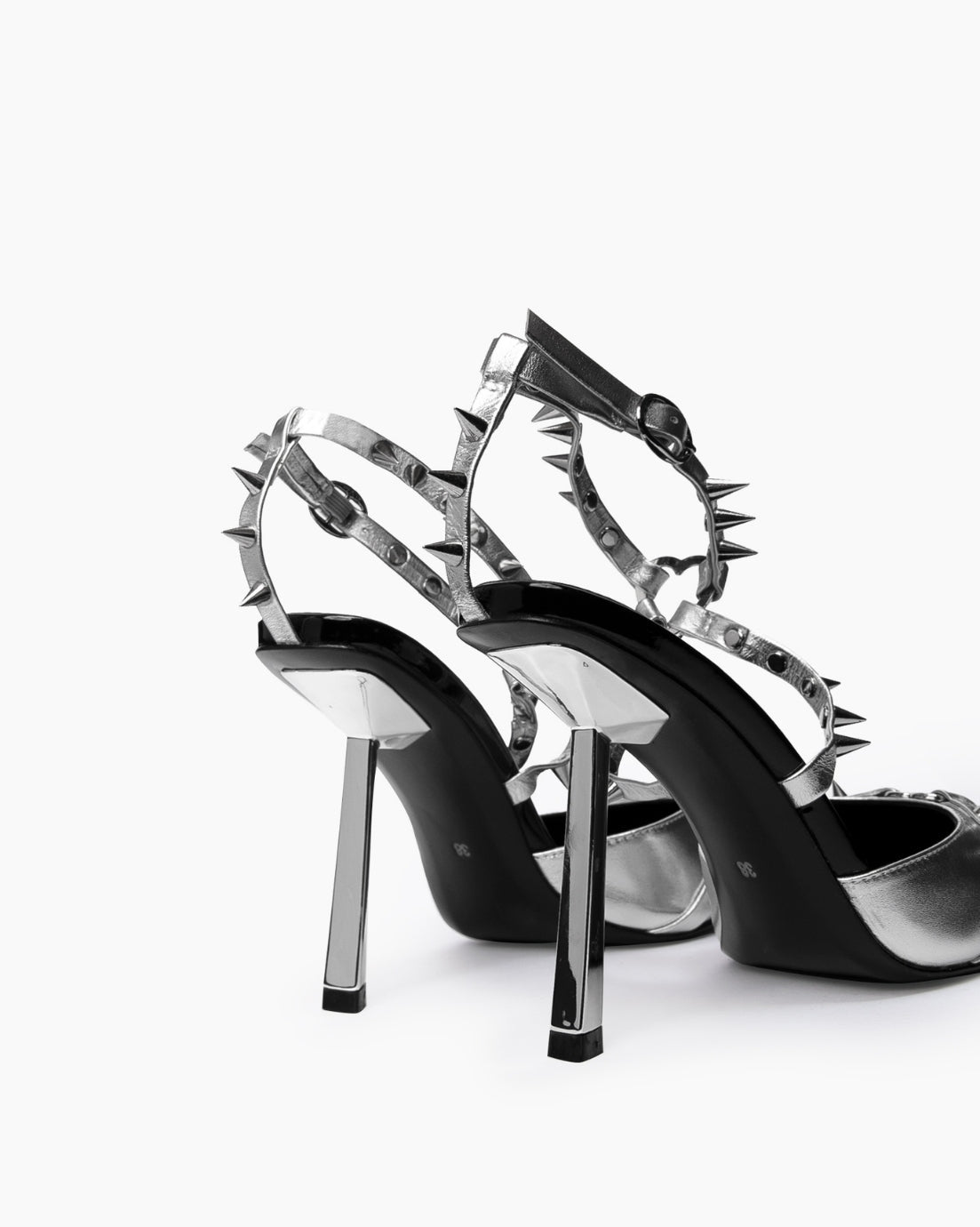 Rear close-up of reflective angular heels and silver spiked ankle straps