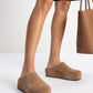 Taupe suede platform clogs worn with black shorts